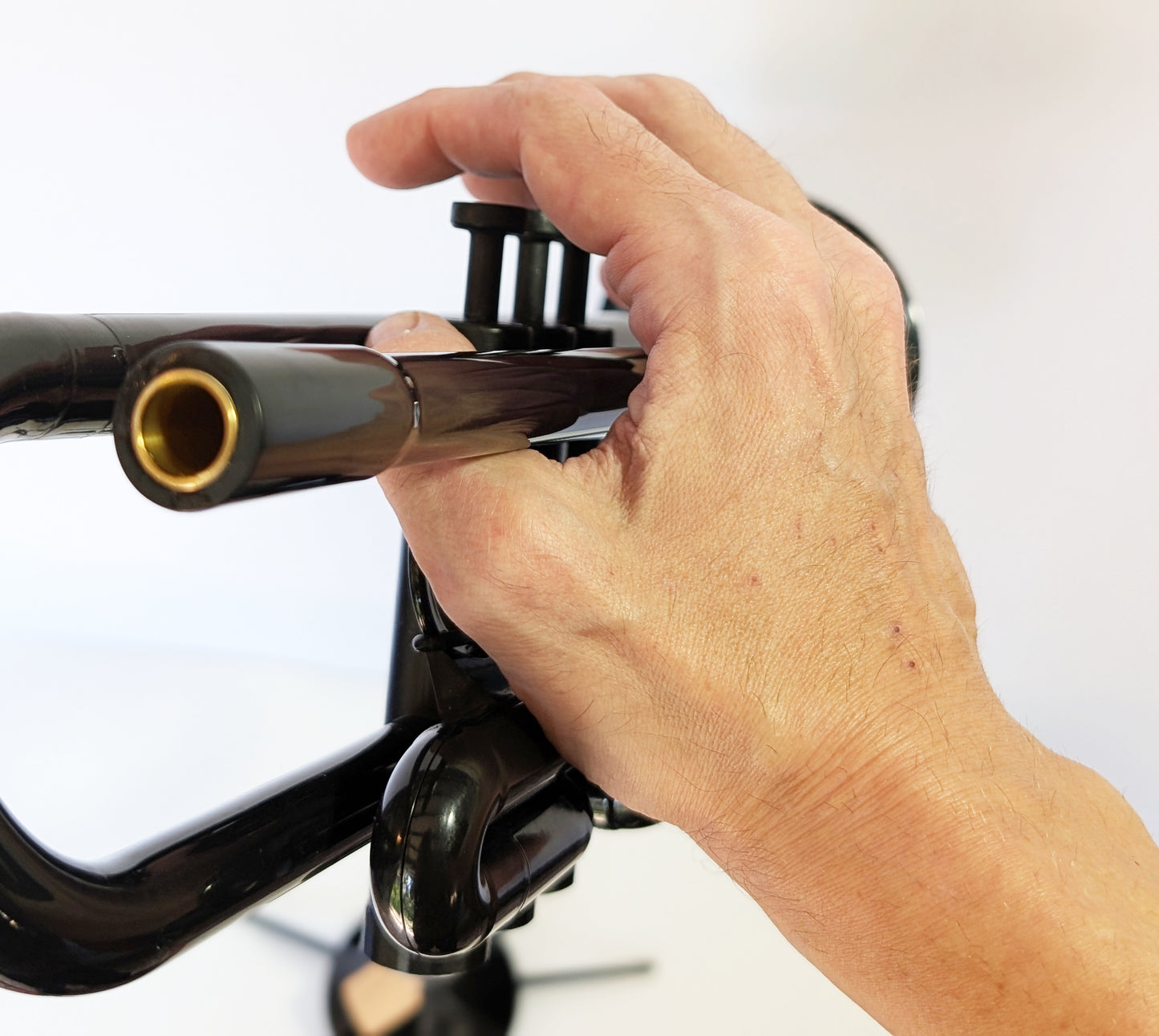 Black plastic trumpet by PNW Music with three valves, designed for students and outdoor use with weather-resistant construction