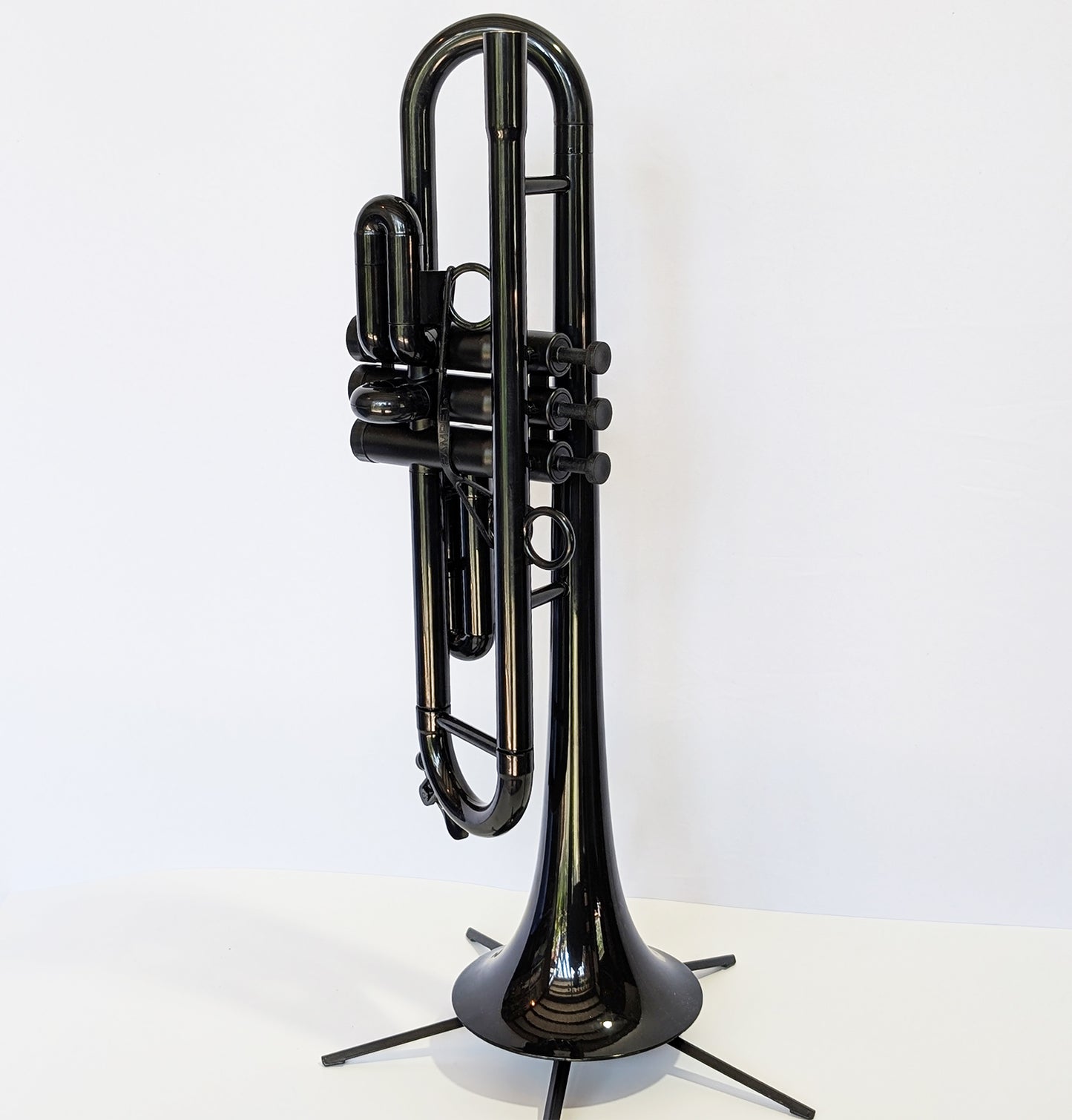 Black plastic trumpet by PNW Music with three valves, designed for students and outdoor use with weather-resistant construction