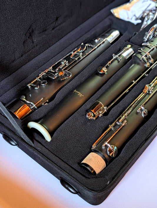 Black plastic student bassoon with dual necks by PNW Music, affordable double reed woodwind instrument for beginners